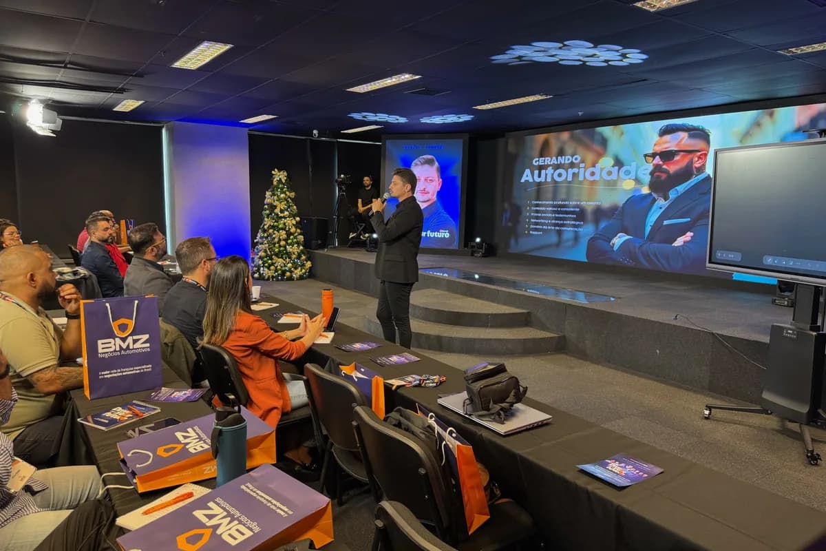 Sala cheia acompanhando a apresentação, com o criativo no telão